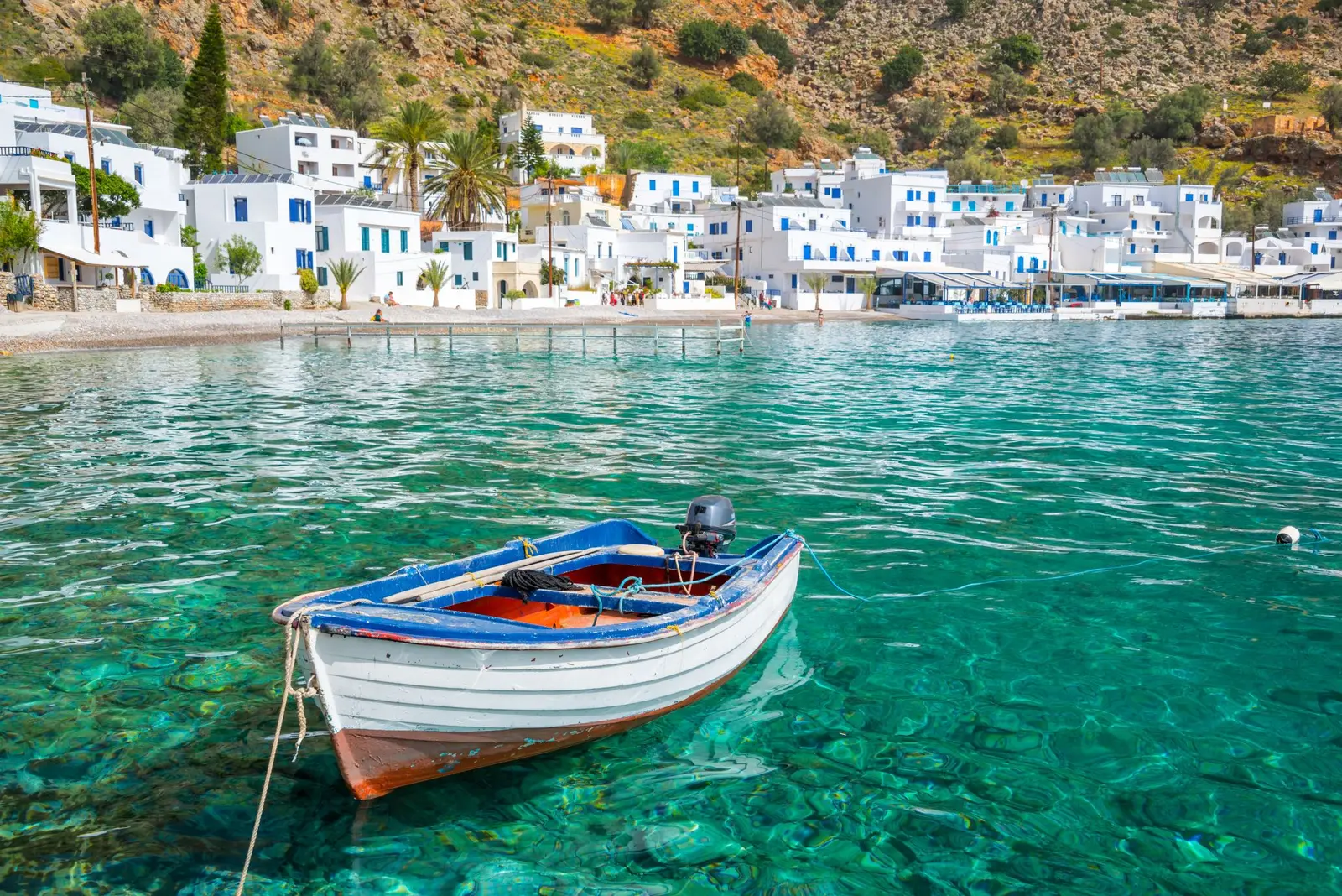 A traditional boat in clear water beside the waterfront on Aegina Island